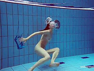 Brunette teen Martina swims underwater in blue bikini at the beach. Her tight pussy shows through in outdoor European pool shower.